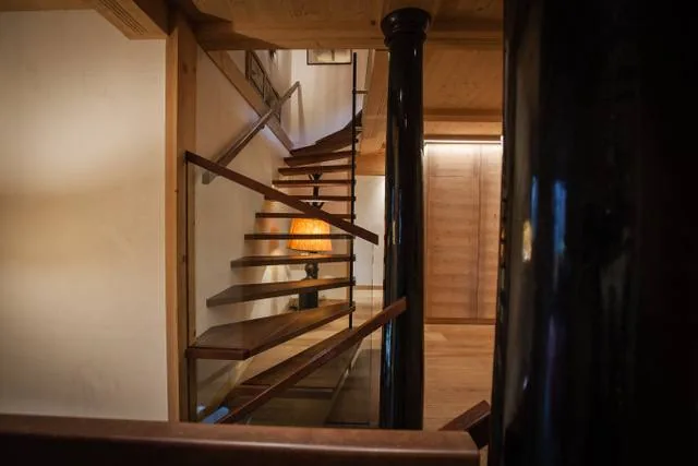 Vue latérale d’un escalier contemporain en bois autour d’un poteau métallique