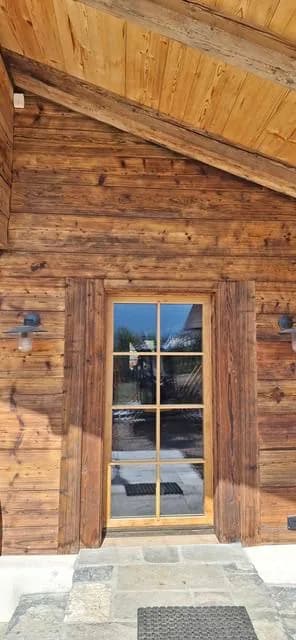 Porte vitrée en bois intégrée à une façade de chalet
